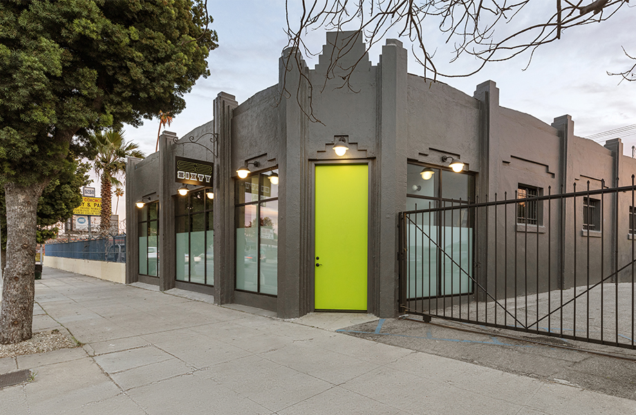 Building with green door and black fence Edificio con puerta verde y reja verde